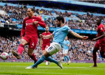 Manchester City's Ilkay Gundogan, center, scores his his side's third goal, challenged by Liverpool's Virgil van Dijk during the English Premier League soccer match between Manchester City and Liverpool at Etihad stadium in Manchester, England,Saturday, April 1, 2023. (Jon Super/AP)