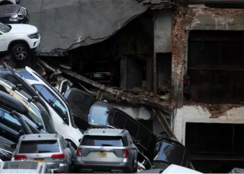 Cars and debris stacked high on a mound of shattered concrete