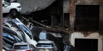 Cars and debris stacked high on a mound of shattered concrete