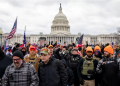 Proud Boys, many wearing orange hats, along with others outside the US Capitol on 6 January 2021